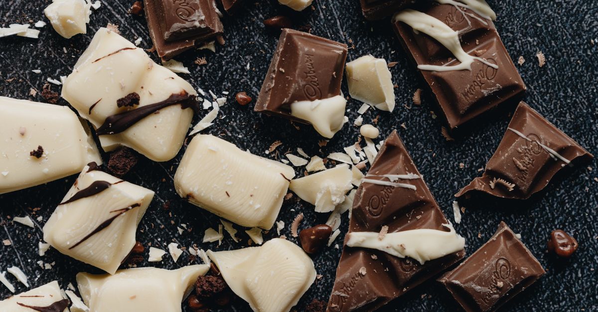 Close-up of assorted milk and white chocolate pieces with artistic drizzle.
